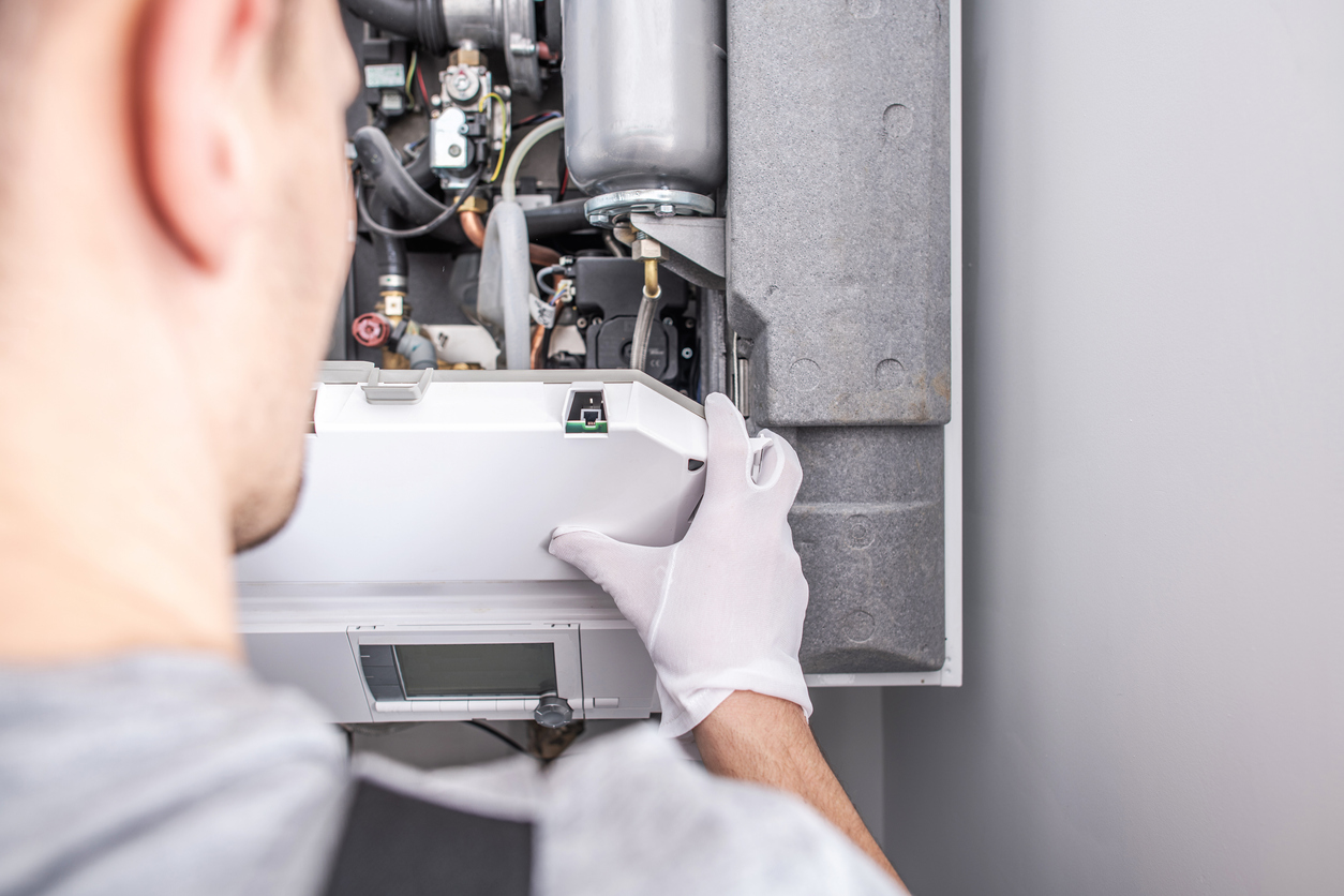 Close up of an HVAC technician repairing a gas furnace